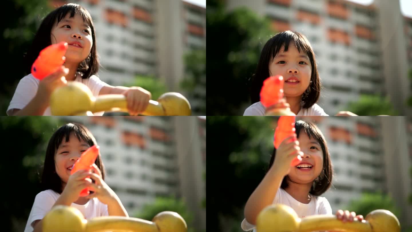 亚洲女孩玩水枪外国人小孩童年开心夏天玩水