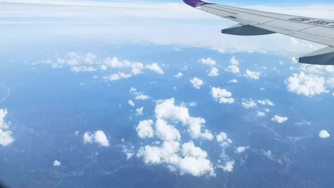 飞机窗外飞行中的云海、山川景色
