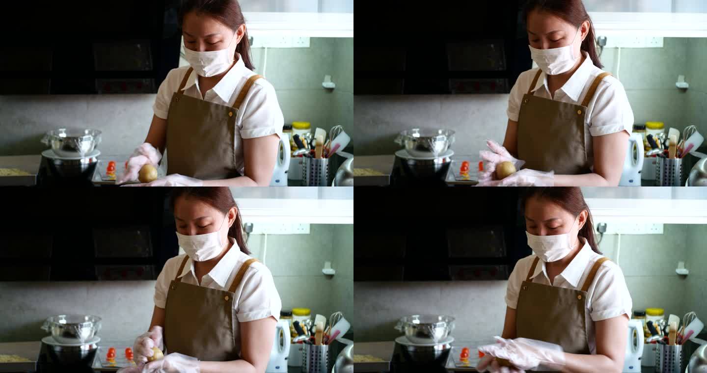 亚洲女人在厨房做月饼面团