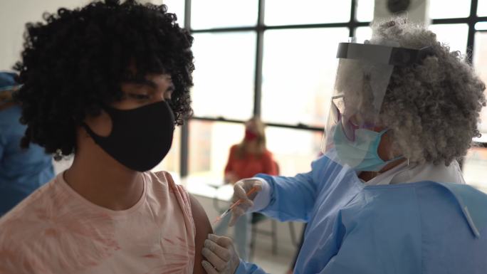正在接种疫苗的年轻人-戴口罩