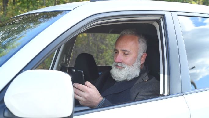成年男子在车上用智能手机写短信