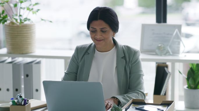 一位成熟的女商人在办公室用笔记本电脑工作时休息的4k视频片段