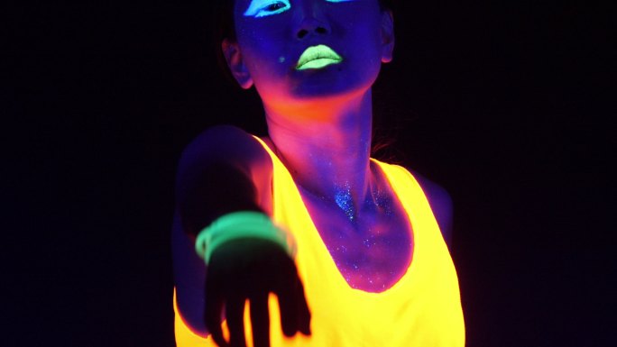 性感的赛博锐舞女子在紫外线黑光下穿着荧光服装拍摄的精彩视频。性感的女孩赛博锐火女子在紫外线黑光下穿着