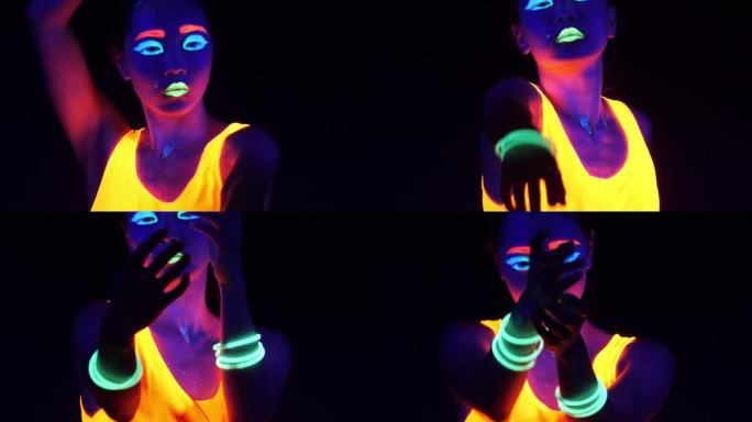 性感的赛博锐舞女子在紫外线黑光下穿着荧光服装拍摄的精彩视频。性感的女孩赛博锐火女子在紫外线黑光下穿着