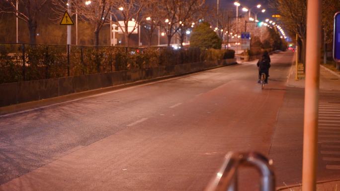 夜晚道路的行人骑自行车下班回家
