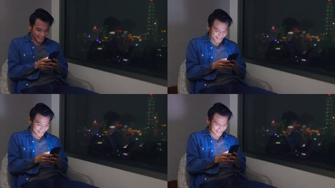 男人玩手机游戏青年男人深夜玩手机灯光闪烁