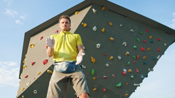 SLO MO攀爬者的肖像在攀爬墙上摆姿势