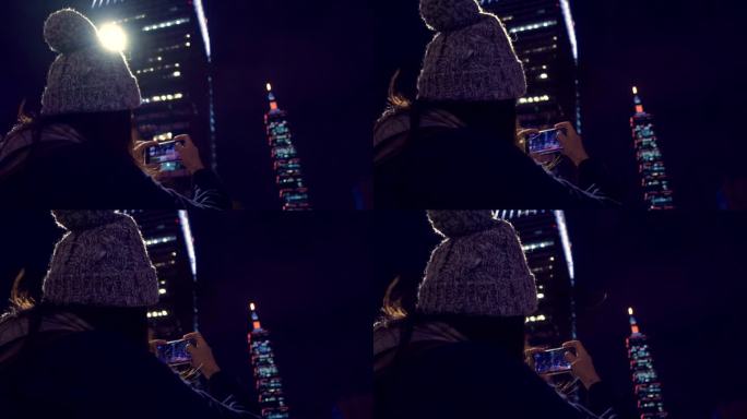 女游客使用智能手机拍摄台湾台北塔