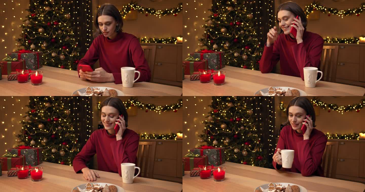 一位穿着红色毛衣的年轻美女正在打电话，然后面带微笑地用智能手机交谈，她坐在桌旁，手里拿着蜡烛