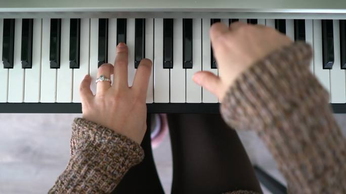 女人弹钢琴的手。弹钢琴黑白键正视图