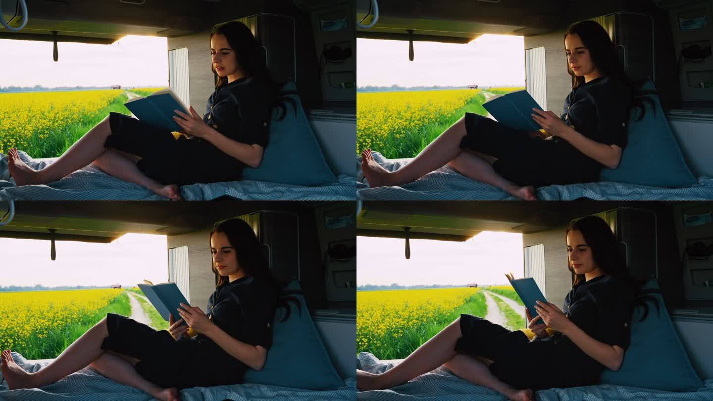 DS女子在停在油菜花田边的露营车的小屋里看书