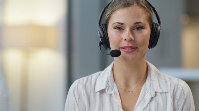 美女呼叫中心客服通过无线耳机帮助客户上网。年轻自信的总机接线员通过电话求助热线帮助客户。此处帮助解决