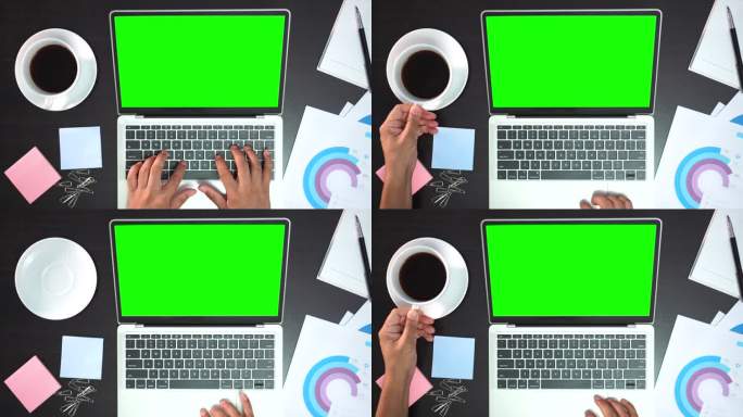 从上方看，在白色办公桌上使用绿色屏幕的笔记本电脑的男性双手