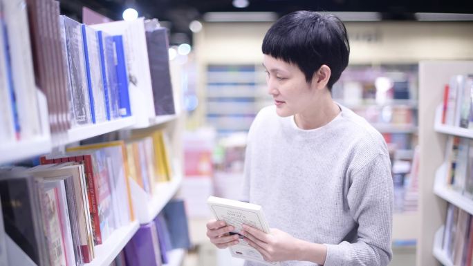 女人在书店买书。亚洲女人喜欢读书