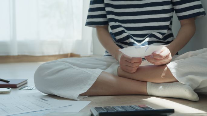 女性通过信用卡账单复查。女性在经济上有问题。债务概念。