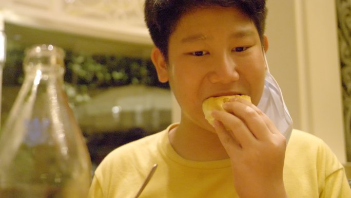 快乐的亚洲男孩在夜晚与家人、生活方式理念一起在餐厅吃披萨和意大利美食。