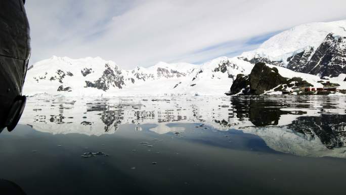 南极洲冰山间漂浮着游客的小船