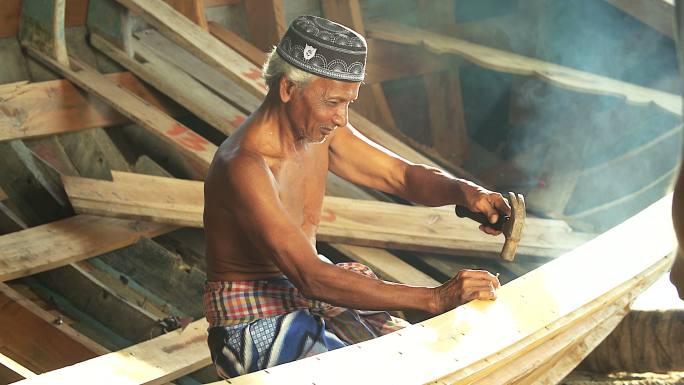 亚洲老年木匠制作木船。