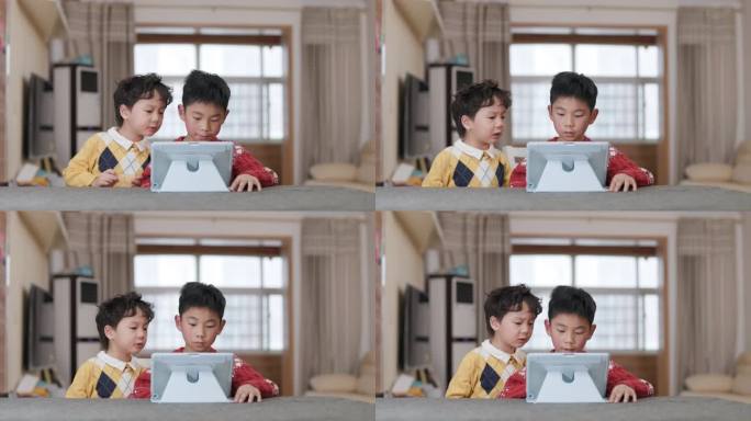 两个小男孩在桌上玩数字平板电脑