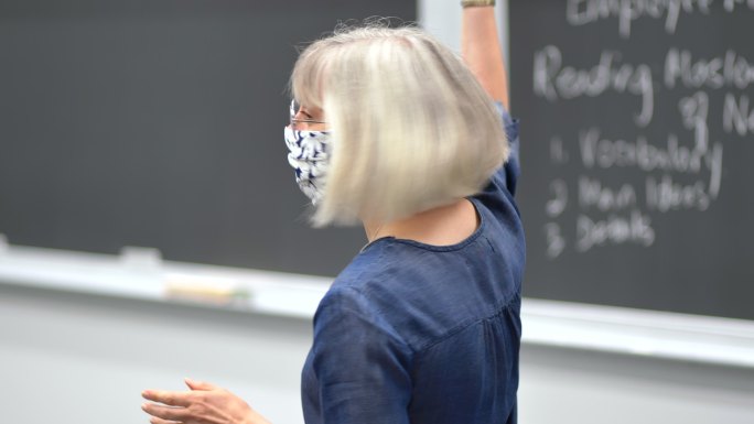大学生上课戴口罩教学对着黑板讲解