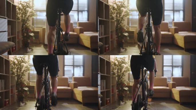 亚洲女子自行车运动员。她在家里锻炼身体。在教练机上骑自行车，玩在线自行车游戏
