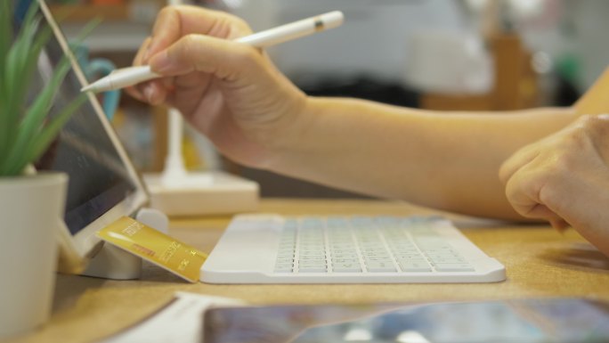 成年人在家工作时，在厨房里用苹果铅笔和数字平板电脑，隔离生活方式的概念。