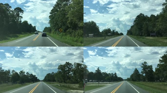 佛罗里达州米德尔堡的一条笔直的乡村道路上，夏日的流逝，天空中形成了暴风云