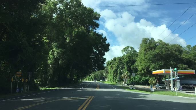 在佛罗里达州的Keystone Heights，天空中乌云密布，夏日的流逝，驱车沿着弯曲的乡村铺面道