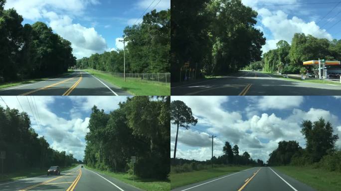 在佛罗里达州的Keystone Heights，天空中乌云密布，夏日的流逝，驱车沿着弯曲的乡村铺面道