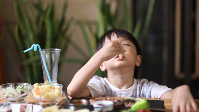 小男孩在餐厅吃饭小孩吃饭独自独立生活吃面