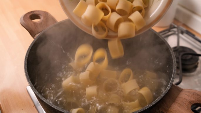 慢动作未煮熟的Paccheri意大利面放入沸水中