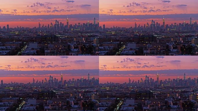 日落时分，曼哈顿天际线在布鲁克林布什维克住宅区上空的夜晚被照亮。镜头平移的无人机视频。