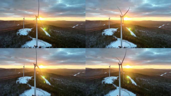 在被白雪覆盖的犹他山脉包围的日出（日落）雾蒙蒙的冬日早晨，风力涡轮机缓慢转动