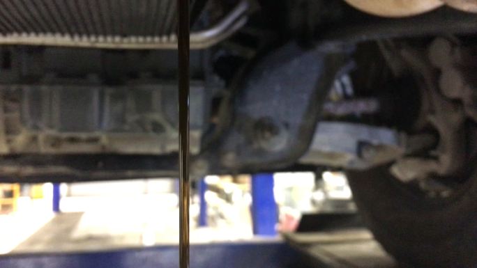 变速箱油液从齿轮箱排入金属排放罐（带筛网）的倾斜镜头