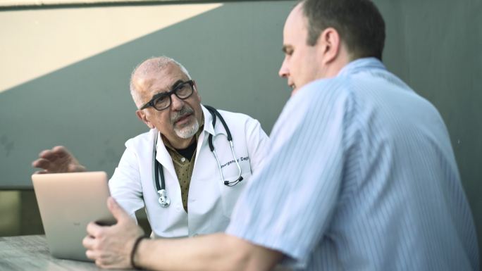 医疗咨询：医生，银发老人，与患者交谈，成年白人男子。