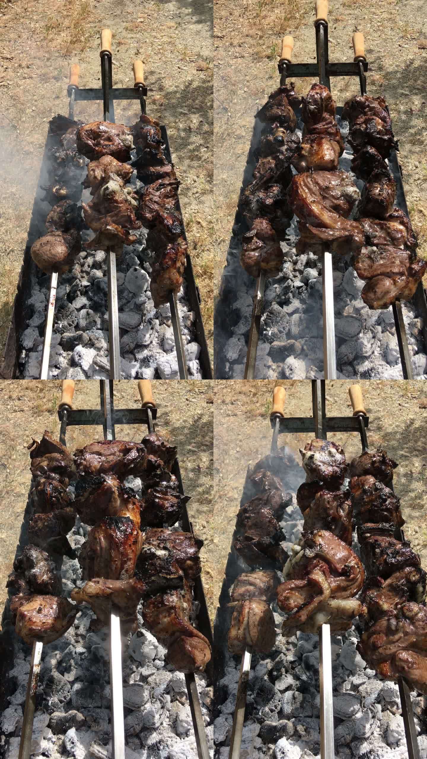俯瞰三个长长的、缓慢旋转的烤串，烤羊肉时，灰烬覆盖的燃烧木炭中冒出缕缕烟雾