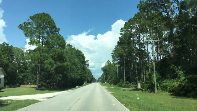 在佛罗里达州米德尔堡附近的乡村公路上，夏季的过度驾车行驶，天空中形成了风暴云