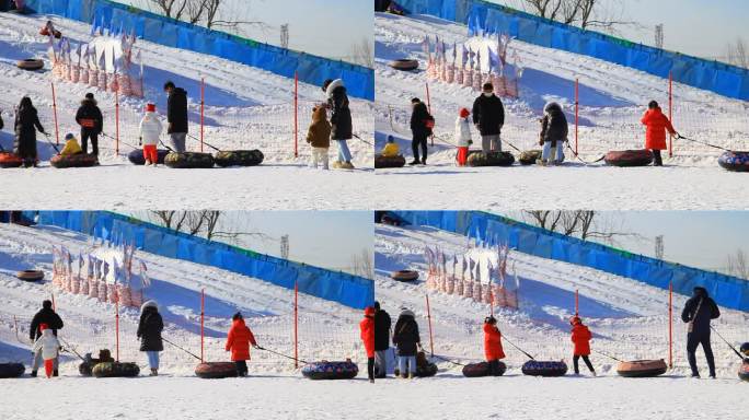 冬季滑雪场人们拉着轮胎依次排队等待滑雪