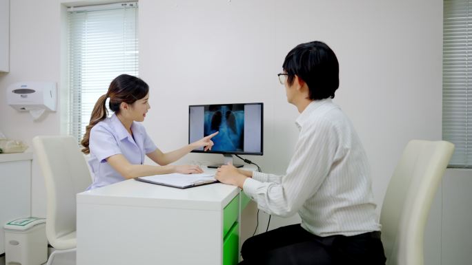 友好的女性治疗师在诊所就诊时与患者交谈。