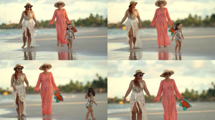 女孩与母亲和祖母在海滩上散步