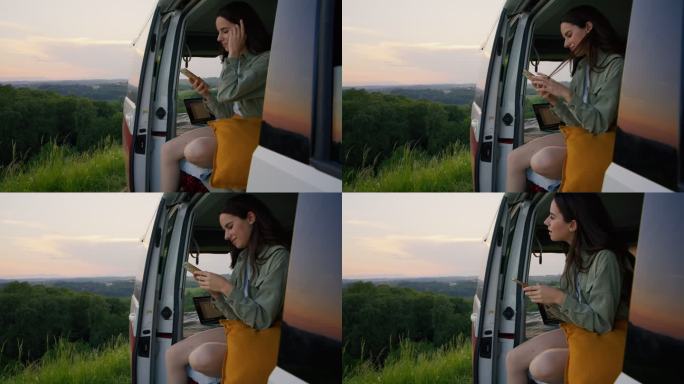 DL年轻女子在货车后部使用智能手机时欣赏风景