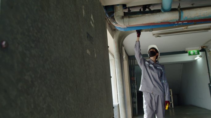 亚洲女技术员检查员检查建筑物内的管道泄漏状况。工程师女性接触