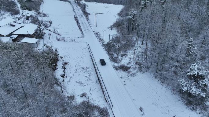 航拍车辆冬天行驶在积雪覆盖的乡村路上4K