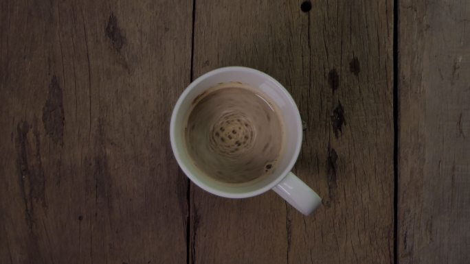 木制桌子上白色杯子里的热咖啡。
