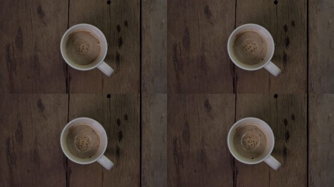 木制桌子上白色杯子里的热咖啡。