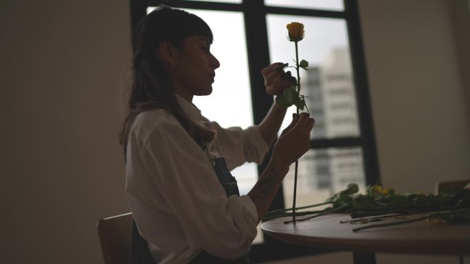 年轻女子在家插花美女插花剪影修剪玫瑰