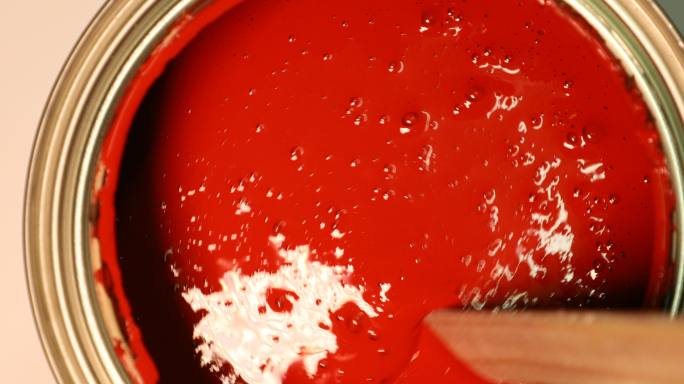 用手动搅拌机混合红色丙烯酸漆