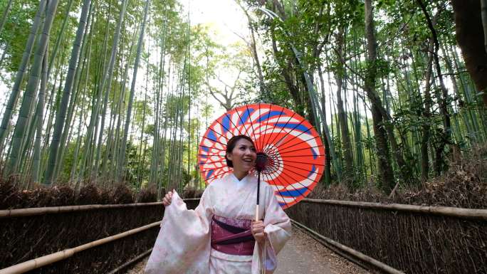 4K鹤拍：日本京都荒山和佐野竹林中，一位身着传统和服的亚洲女性与日本人力车合影，欢迎您来到日本