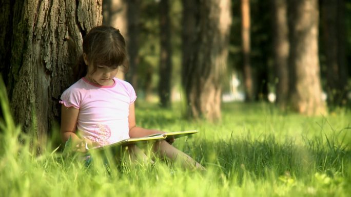 在公园看书小女孩唯美阳光草地翻书看书