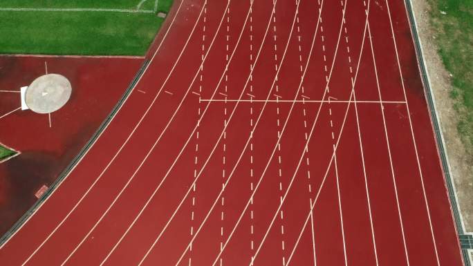 体育场的跑步跑道，颜色为橙色砖块，无人机视角高。